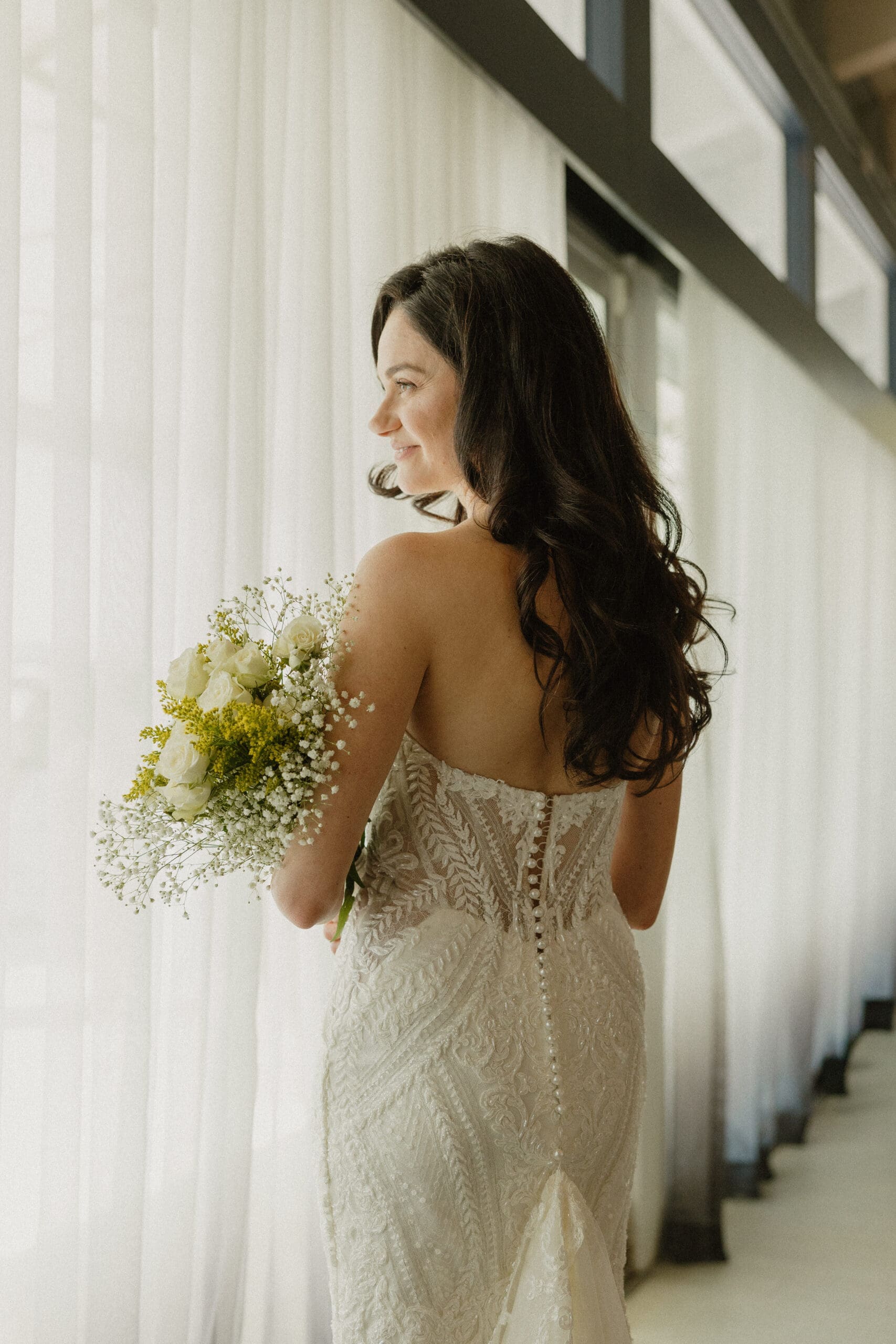 Bride in strapless lace gown holding bouquet at intimate wedding reception, Grateful Palate Fort Lauderdale