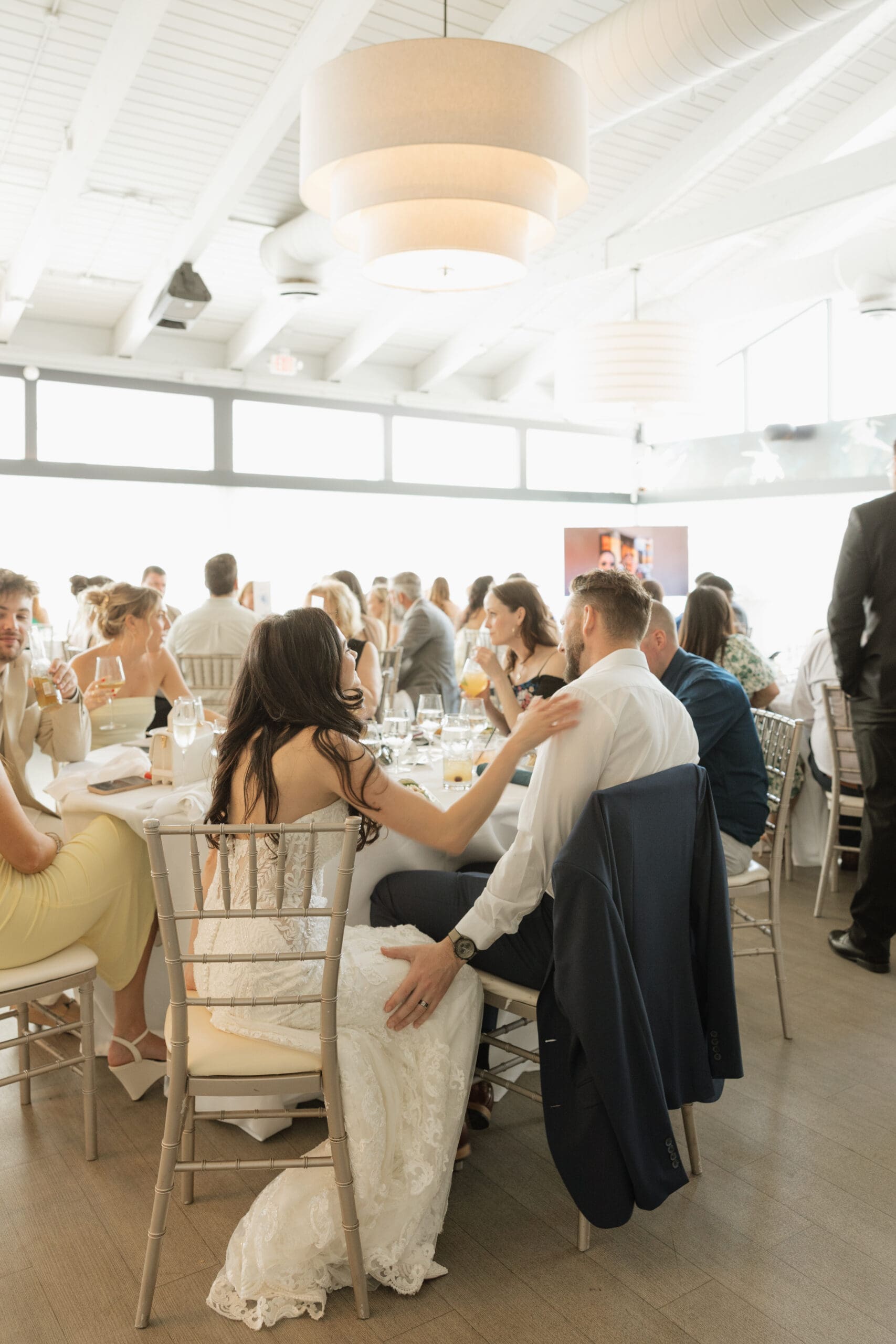 Bride and groom seated at reception dinner table surrounded by guests at Grateful Palate Fort Lauderdale wedding reception