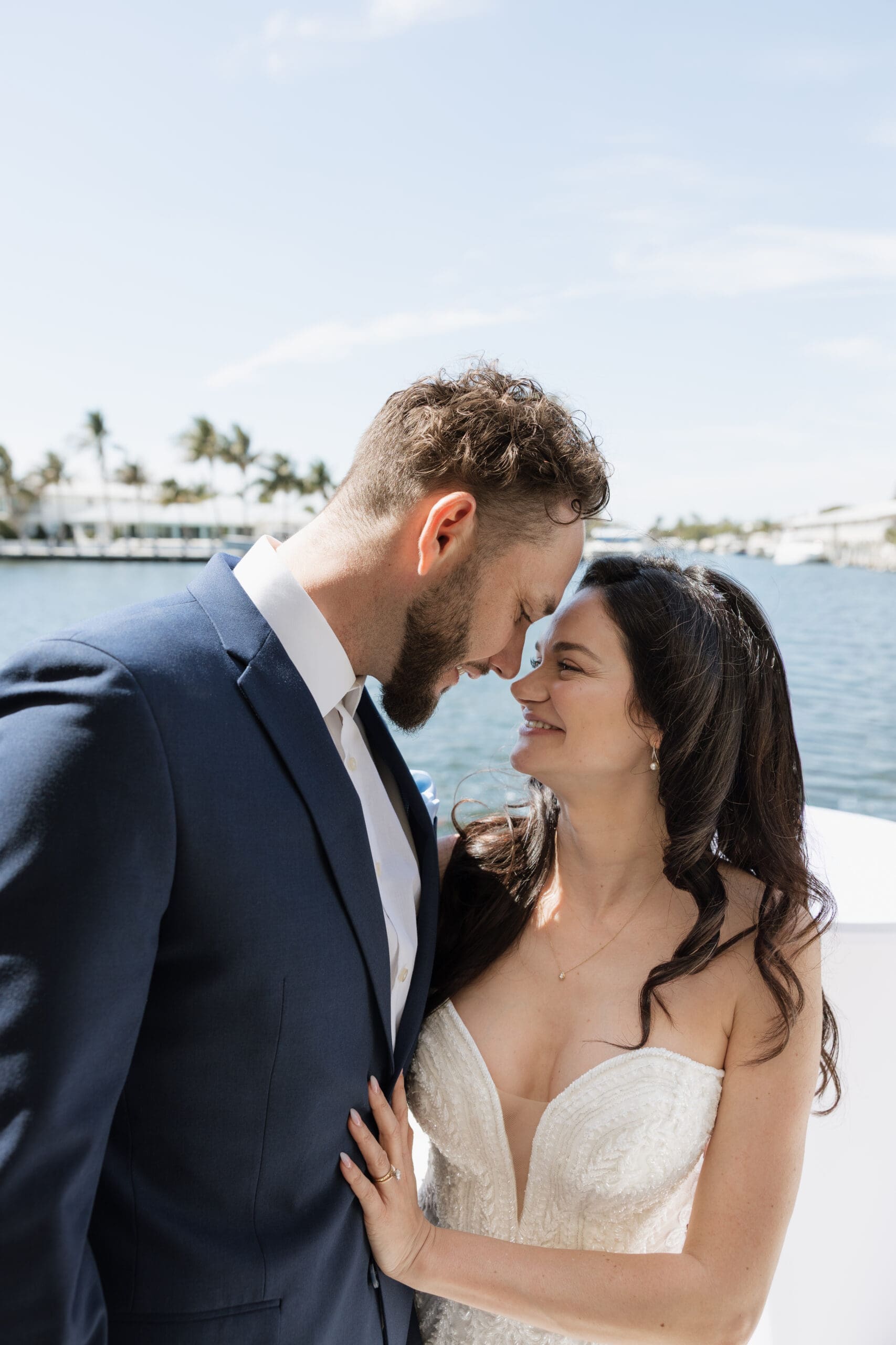 Bride and groom forehead to forehead smiling at each other on waterfront at intimate wedding reception, Grateful Palate Fort Lauderdale