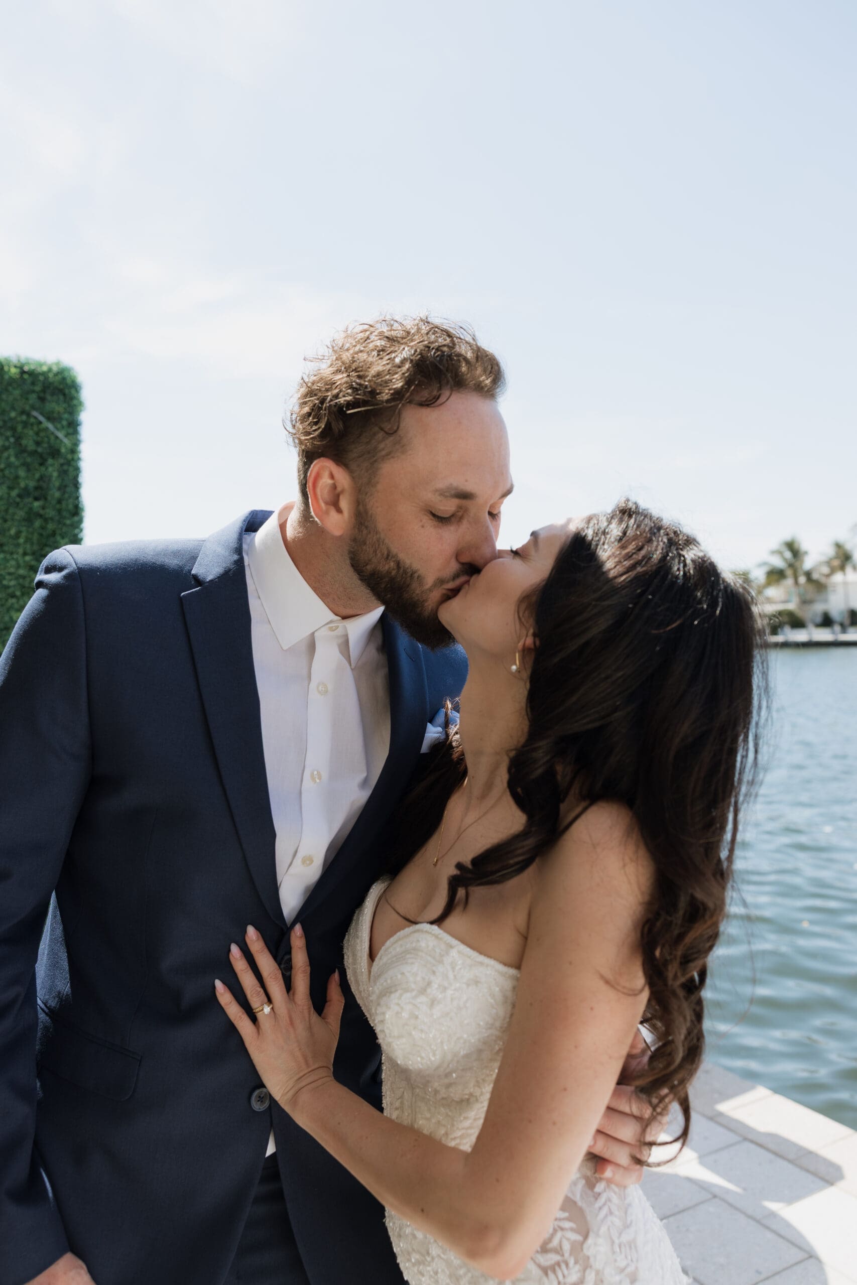 Bride and groom kissing on waterfront patio at intimate wedding reception, Grateful Palate Fort Lauderdale