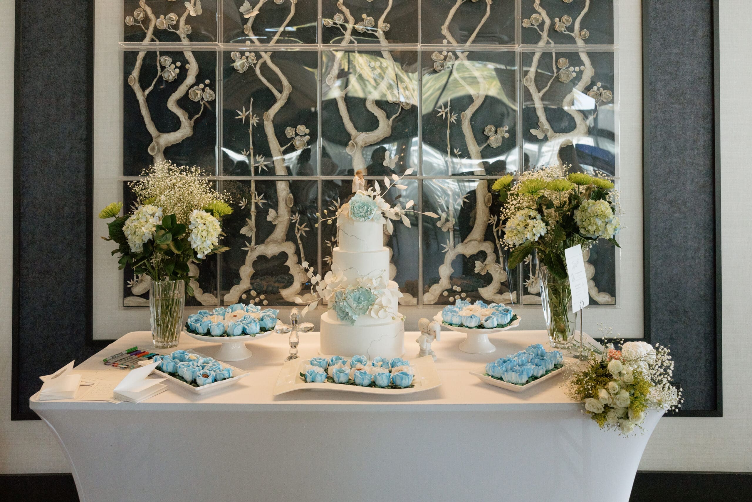 Four-tier wedding cake with blue sugar flowers and dessert display at intimate reception, Grateful Palate Fort Lauderdale